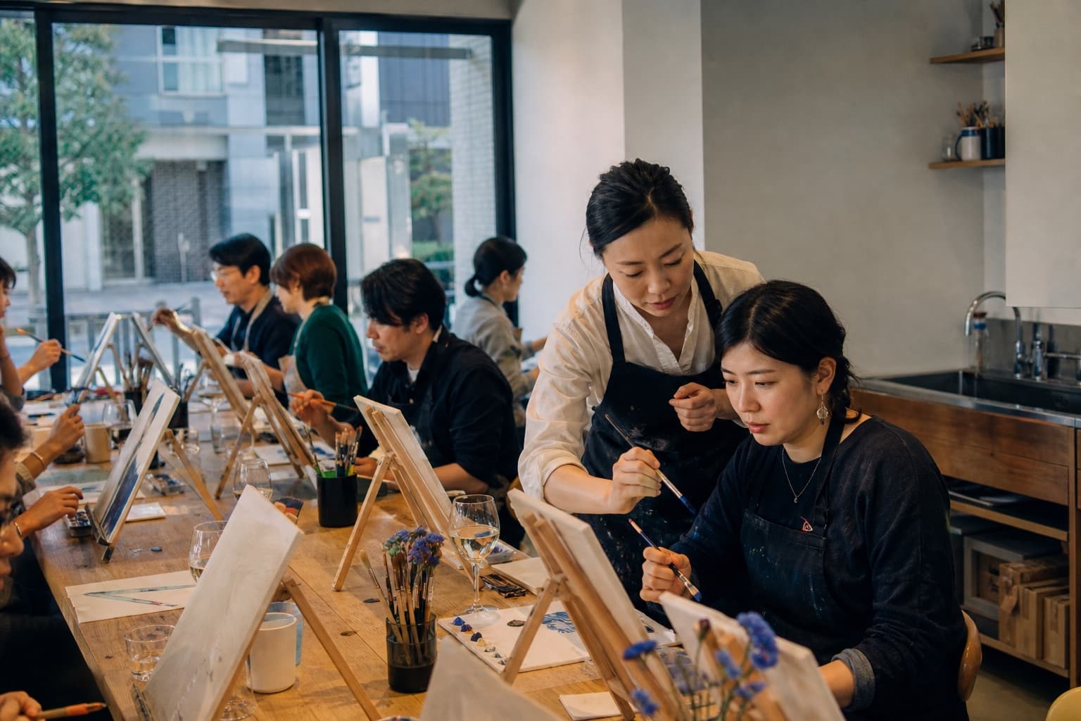 日本のペイントアンドシップクラスで講師が参加者をサポートしている様子